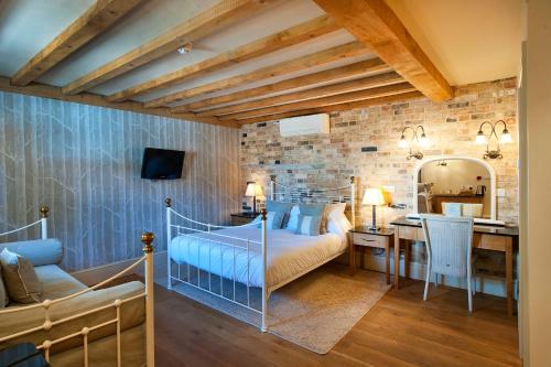 a bedroom with a bed and a desk at The Fox by Greene King Inns in Bury Saint Edmunds