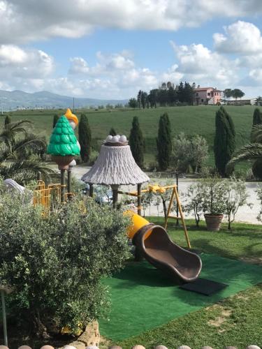 a garden with a playground with a slide at Le case della baracchina in Pisa
