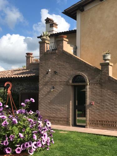 a brick building with flowers in the yard at Le case della baracchina in Pisa