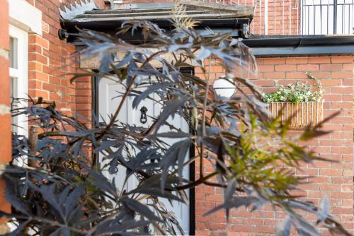 a brick building with a white door and a plant at The Dartmouth Boutique B &B in Dartmouth
