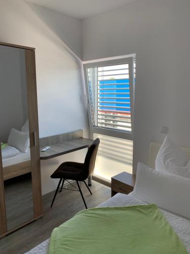 a bedroom with a bed and a chair and a window at TWT Motel in Triptis