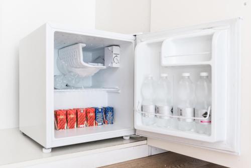 an open refrigerator filled with milk and soda at Affittacamere My Home in La Spezia