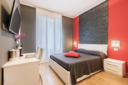 ラ・スペツィアにあるアフィッタカメレ マイ ホームの赤いアクセントの壁のベッド1台が備わるベッドルーム1室が備わります。