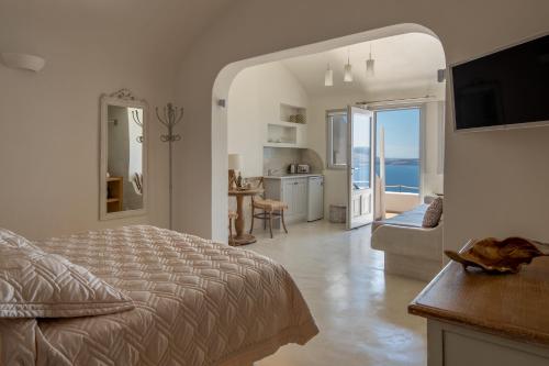 une chambre avec un lit et une vue sur l'océan dans l'établissement Strogili, à Oia