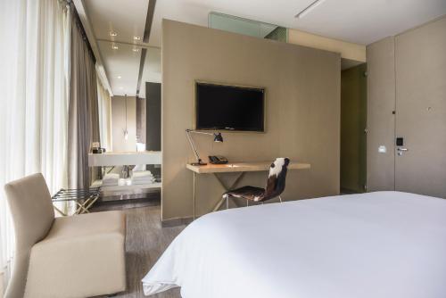 a living room with a television and a bed at BOG Hotel a member of Design Hotels in Bogotá