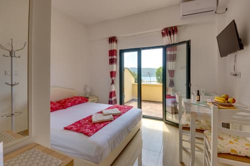 a bedroom with a bed and a balcony at Apartmani Bozinovic in Herceg-Novi