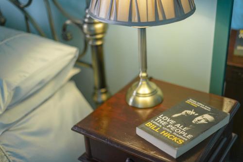 a lamp on a table next to a bed with a book at Golden Eagle in Chester