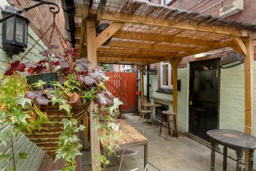 a patio with a wooden pergola with plants at Golden Eagle in Chester