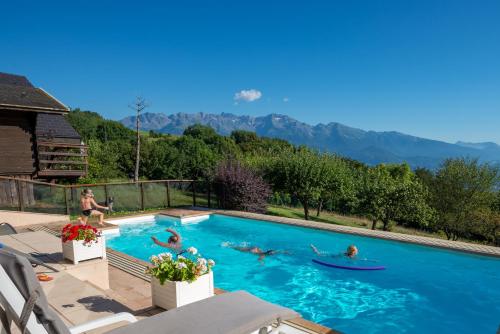 eine Gruppe von Personen, die in einem Schwimmbad schwimmen in der Unterkunft Chalets du Vieux Frêne in Saint-Hilaire