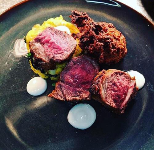 a plate of food with meat and eggs on it at The Tormaukin in Glendevon