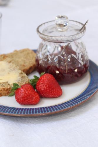 un piatto con fragole e un barattolo di marmellata di Le Chaton Rouge a Saint-Pierre-du-Lorouër