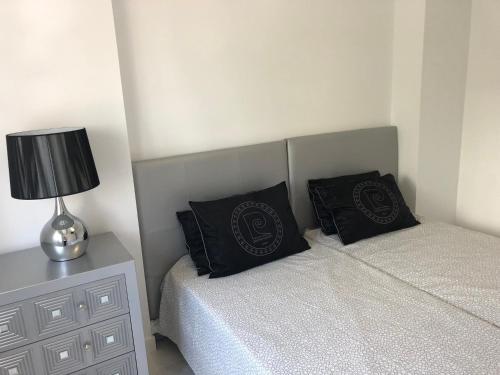 1 dormitorio con 2 camas y mesita de noche con lámpara en Bubu Beach 1-B en Los Cristianos