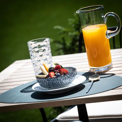 a bowl of fruit and a glass of orange juice on a table at Bed & Breakfast Jezuietenplein 21 in Oudenaarde