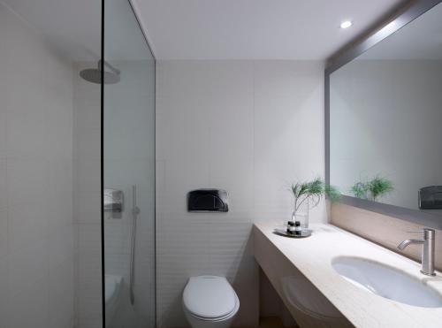 y baño con aseo, lavabo y ducha. en 9 Muses Santorini Resort, en Perivolos