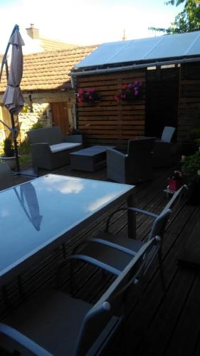 une terrasse avec une table, des chaises et un parasol dans l'établissement LES 4 VENTS, à Saint-Berain-sur-Dheune