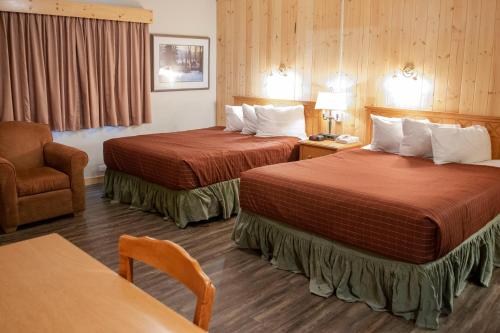 a hotel room with two beds and a chair at Aspen Village in Waterton Park