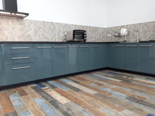 cocina con armarios azules y suelo de madera en Hub Hostel Seville, en Sevilla