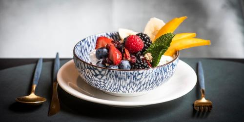 a bowl of fruit on a plate on a table at Bed & Breakfast Jezuietenplein 21 in Oudenaarde