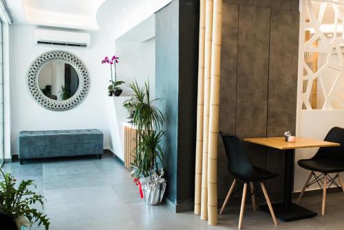 a living room with a table and chairs and a mirror at Margarita Hotel in Firostefani