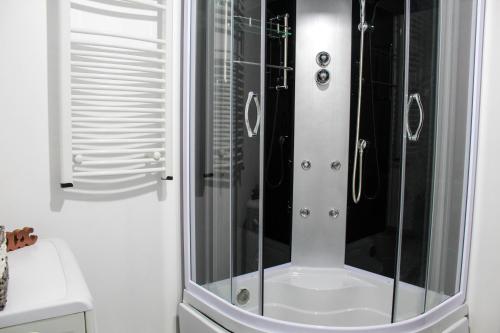 a shower with a glass door in a bathroom at Nirvana Apartament in Bucharest