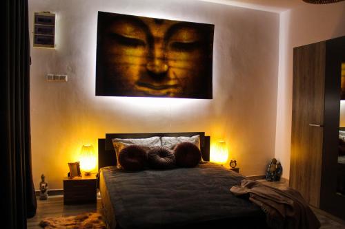 a bedroom with a bed with a painting of a face at Nirvana Apartament in Bucharest