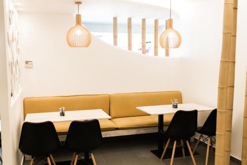 a couch in a restaurant with two tables and chairs at Margarita Hotel in Firostefani