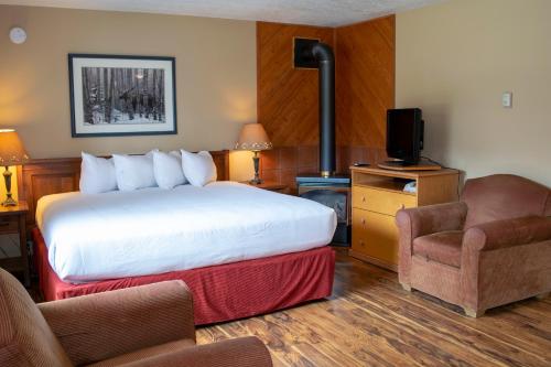 ein Hotelzimmer mit einem Bett und einem Stuhl in der Unterkunft Aspen Village in Waterton Park