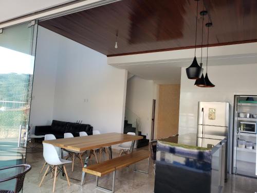 une cuisine et une salle à manger avec une table et des chaises en bois dans l'établissement Casa alto padrão Capitólio Lago Vitória, à Capitólio