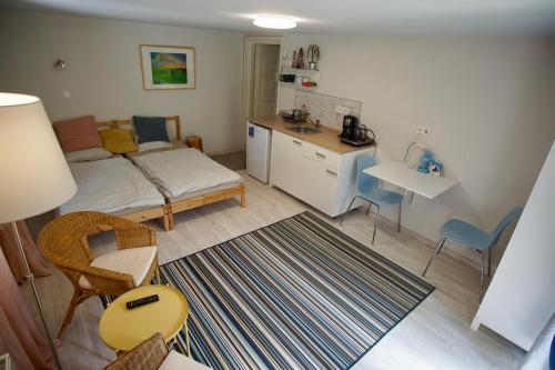 ein kleines Wohnzimmer mit einem Bett und einer Küche in der Unterkunft Das Tulpen Apartment in Weiden am See