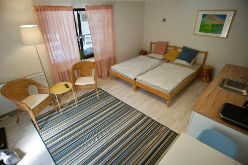 a small room with a bed and chairs and a table at Das Tulpen Apartment in Weiden am See