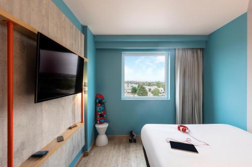 a bedroom with a large white bed with a window at ibis budget Aguascalientes Norte in Aguascalientes