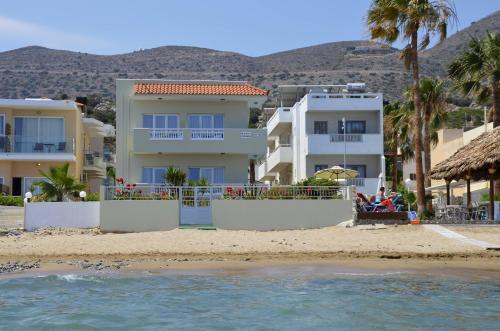 - une vue sur une plage avec des maisons et des palmiers dans l'établissement Seagull Studios, à Stalida