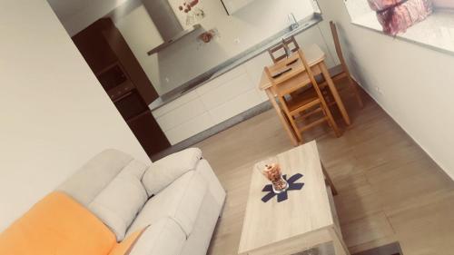 Apartamento Xardin في موتشيا: غرفة معيشة مع أريكة بيضاء وطاولة قهوة