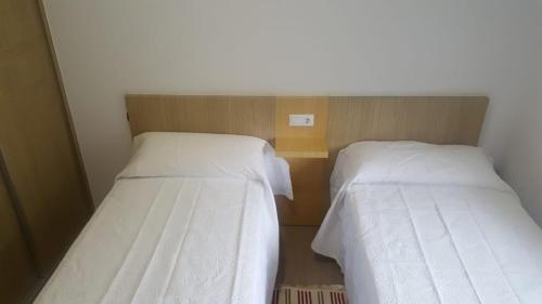 two beds sitting next to each other in a room at Apartamento Xardin in Muxia