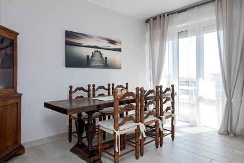 a dining room with a wooden table and chairs at Appartamento Alex Vista Mare in Lido di Camaiore