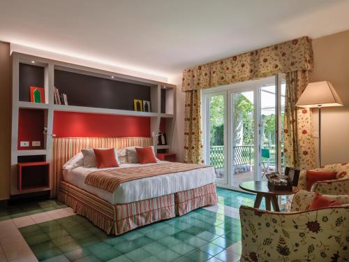 a bedroom with a large bed and a living room at Hotel Hermitage in Forte dei Marmi