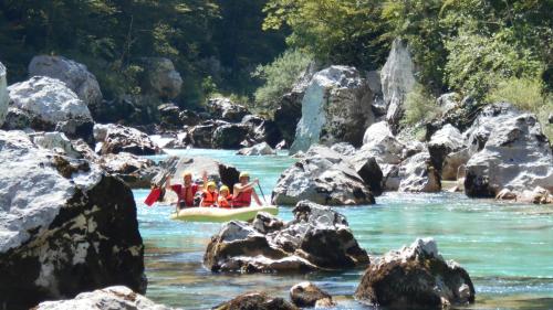 a group of people on a raft in a river at Trnovo ob Soci Kuhala in Kobarid