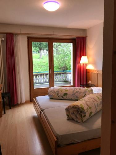 una camera d'albergo con due letti e una finestra di Hotel Val d`Arca a Stampa