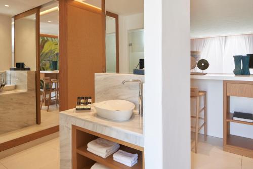 a bathroom with a sink and a toilet at Myconian Kyma - Design Hotels in Mikonos