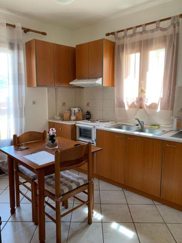 a kitchen with wooden cabinets and a table and a table and chairs at Ifigenia Apartments in Ermoupoli
