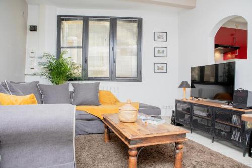 ein Wohnzimmer mit einem Sofa und einem Couchtisch in der Unterkunft Home 12 les Vignes in Châteauneuf-du-Pape