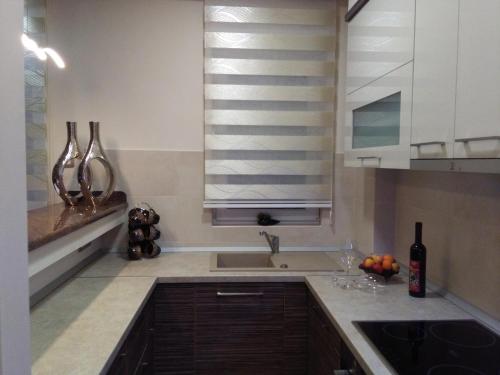 a kitchen with white cabinets and a sink and a window at Apartman LUNA in Trebinje