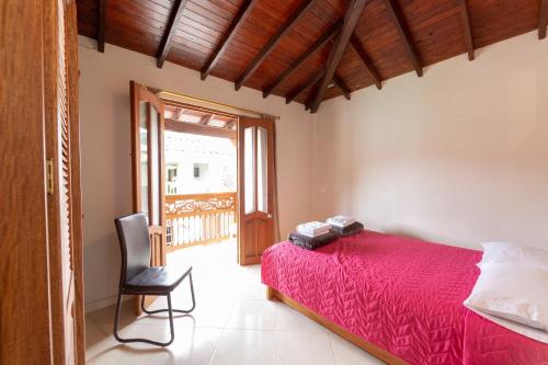 a bedroom with a red bed and a chair at Apartamentos Primavera in Jardin