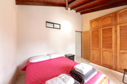 a bedroom with a bed with a pink blanket at Apartamentos Primavera in Jardin