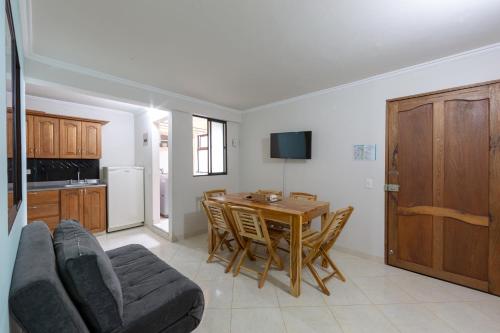 a living room with a table and a couch and a kitchen at Apartamentos Primavera in Jardin
