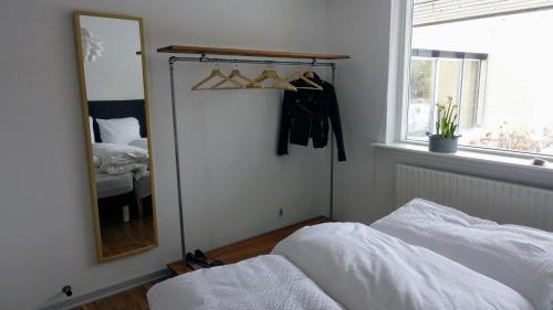 a bedroom with a mirror and a bed and a window at 2 rooms, private kitchen, bathroom, and garden. in Viby