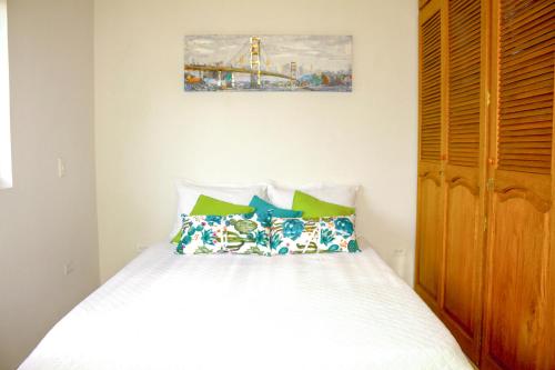 a bedroom with a bed and a painting on the wall at Apartamentos Primavera in Jardin