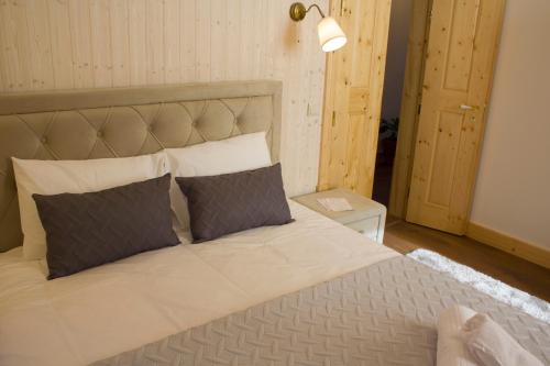 a bedroom with a large bed with two pillows at Casa do Rabana in Leiria