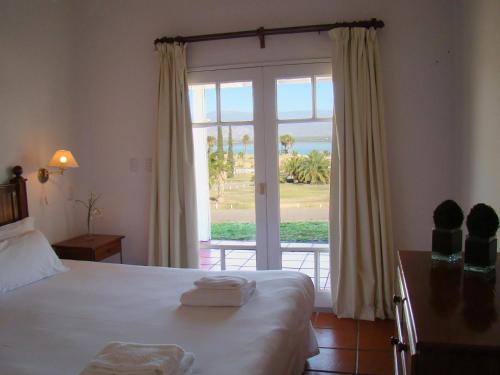 a hotel room with a bed and a large window at Del Bono Beach Complejo Bahia in Las Tapias