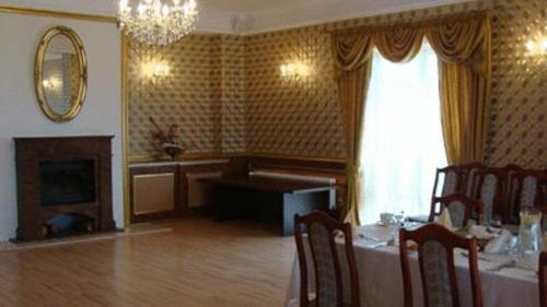 a dining room with a table and a fireplace at Hotel Julian in Szczecin